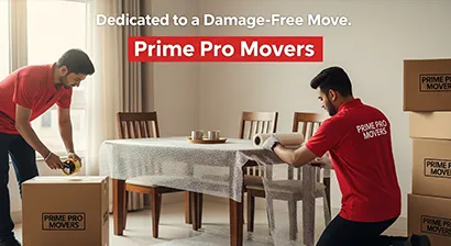 Movers packing a dining table and sealing household boxes inside a Gurugram apartment