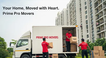 Movers loading household goods onto a moving truck outside a residential building in Gurugram